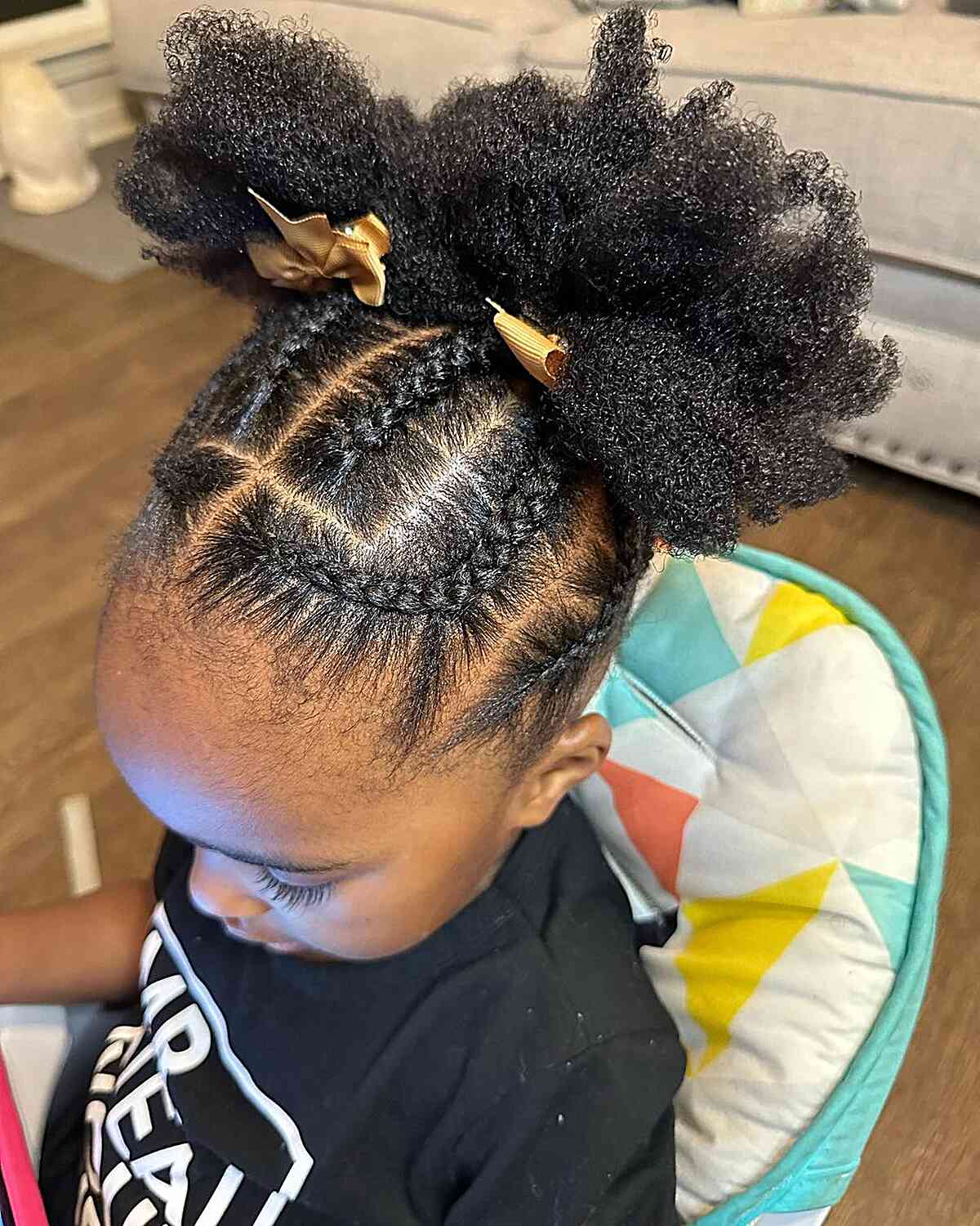 braided updo with double afro puffs and golden bows for black girls