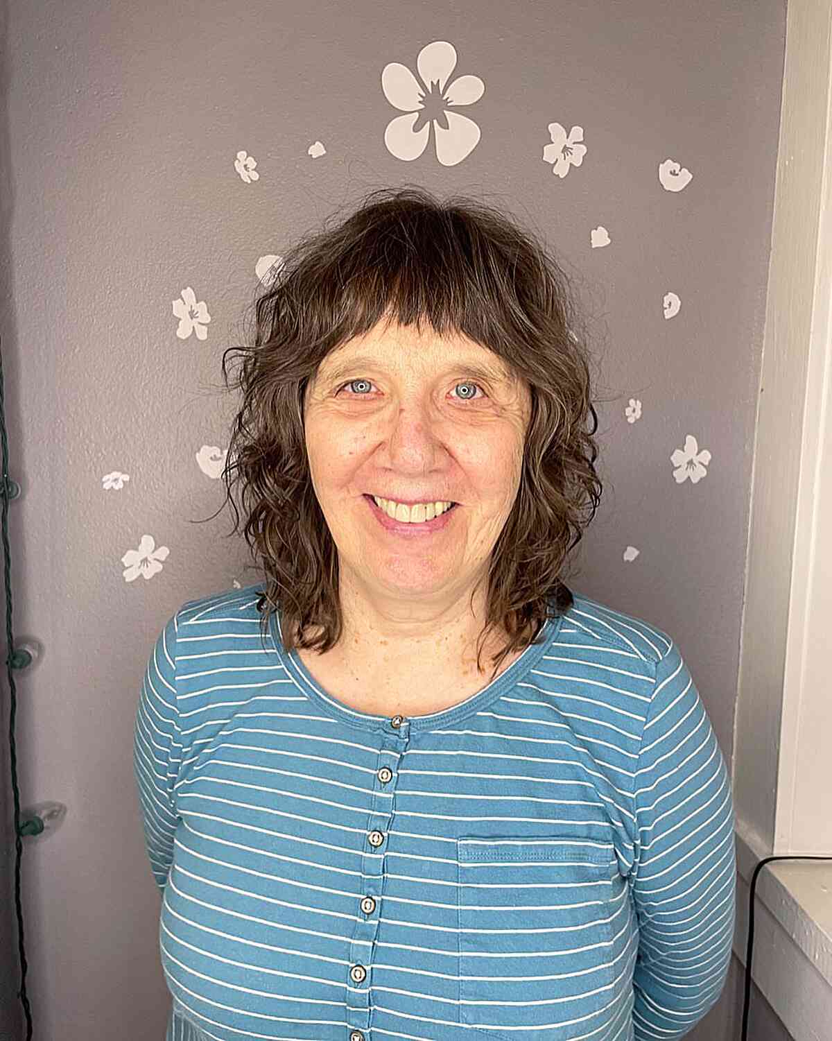 brunette shag with loose curls and mini bangs for old women
