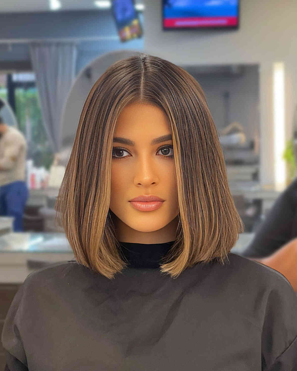 brunette sleek slob cut with face framing highlights