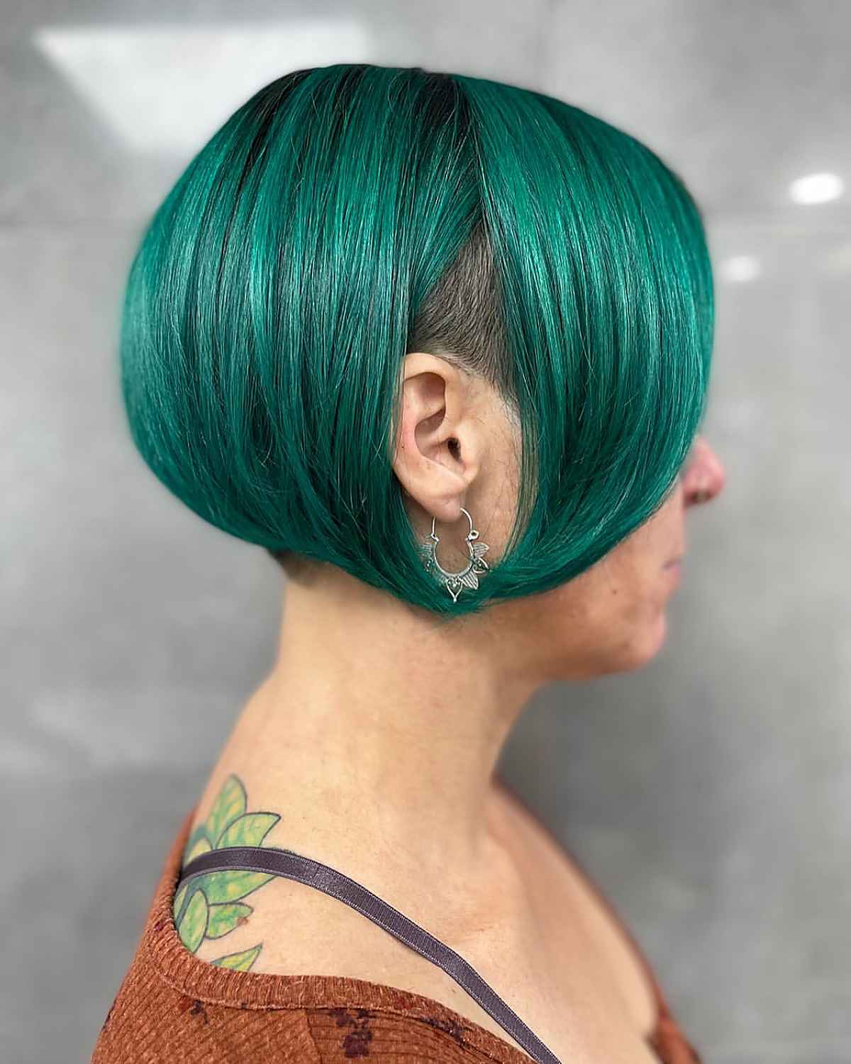 edgy emerald green pixie bob with an undercut for older woman