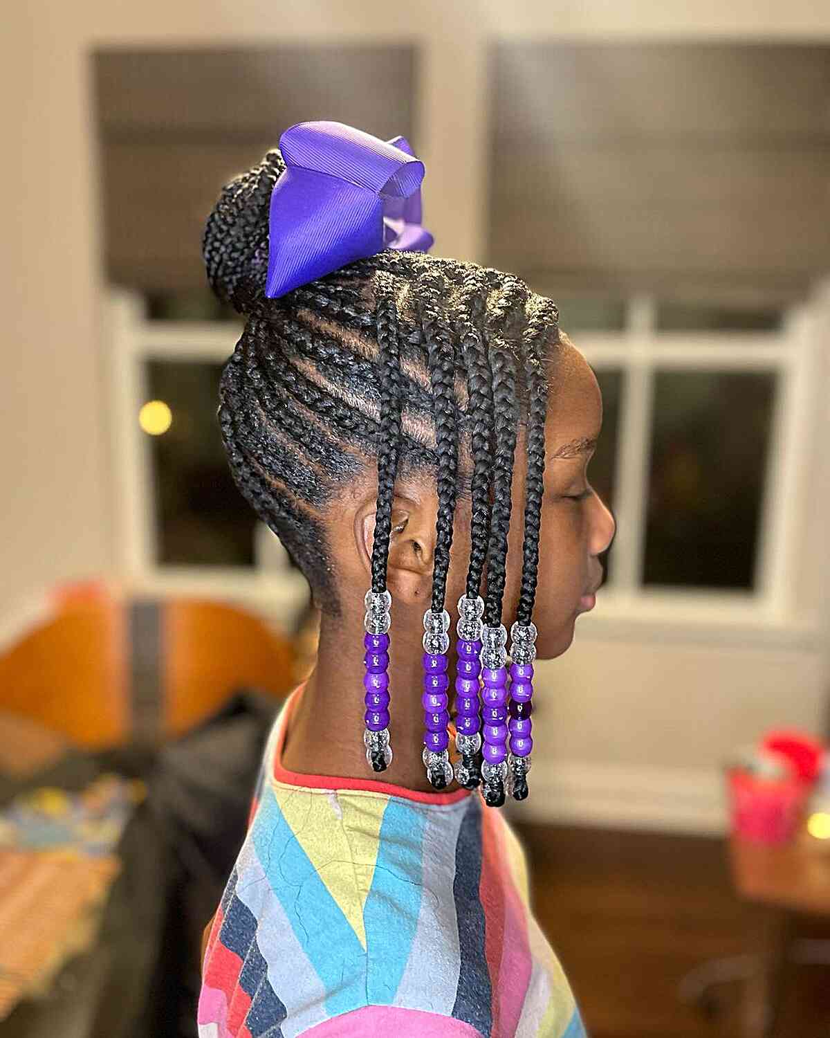 feed in braids in a bun with purple beads for little black girls
