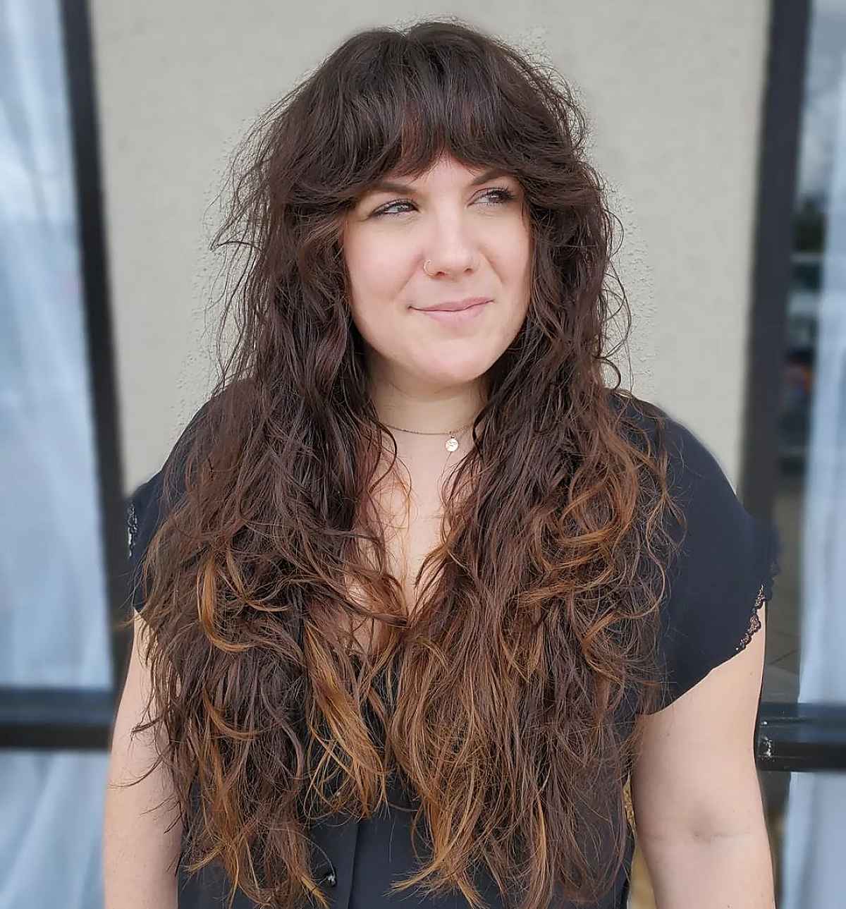 long tousled curls with bangs for a woman over 40 with fine hair