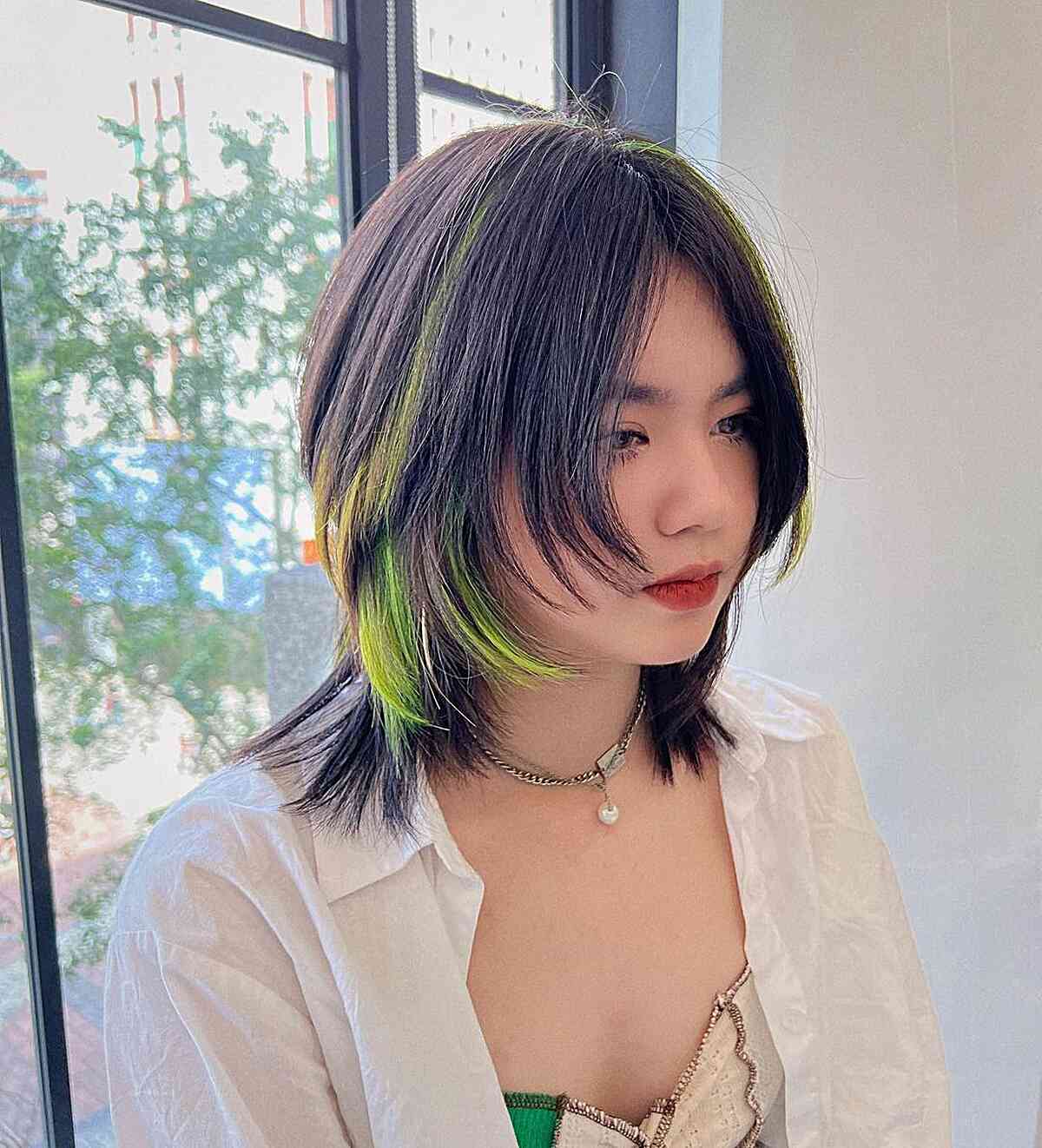 medium length y2k jellyfish haircut with green chunky highlights