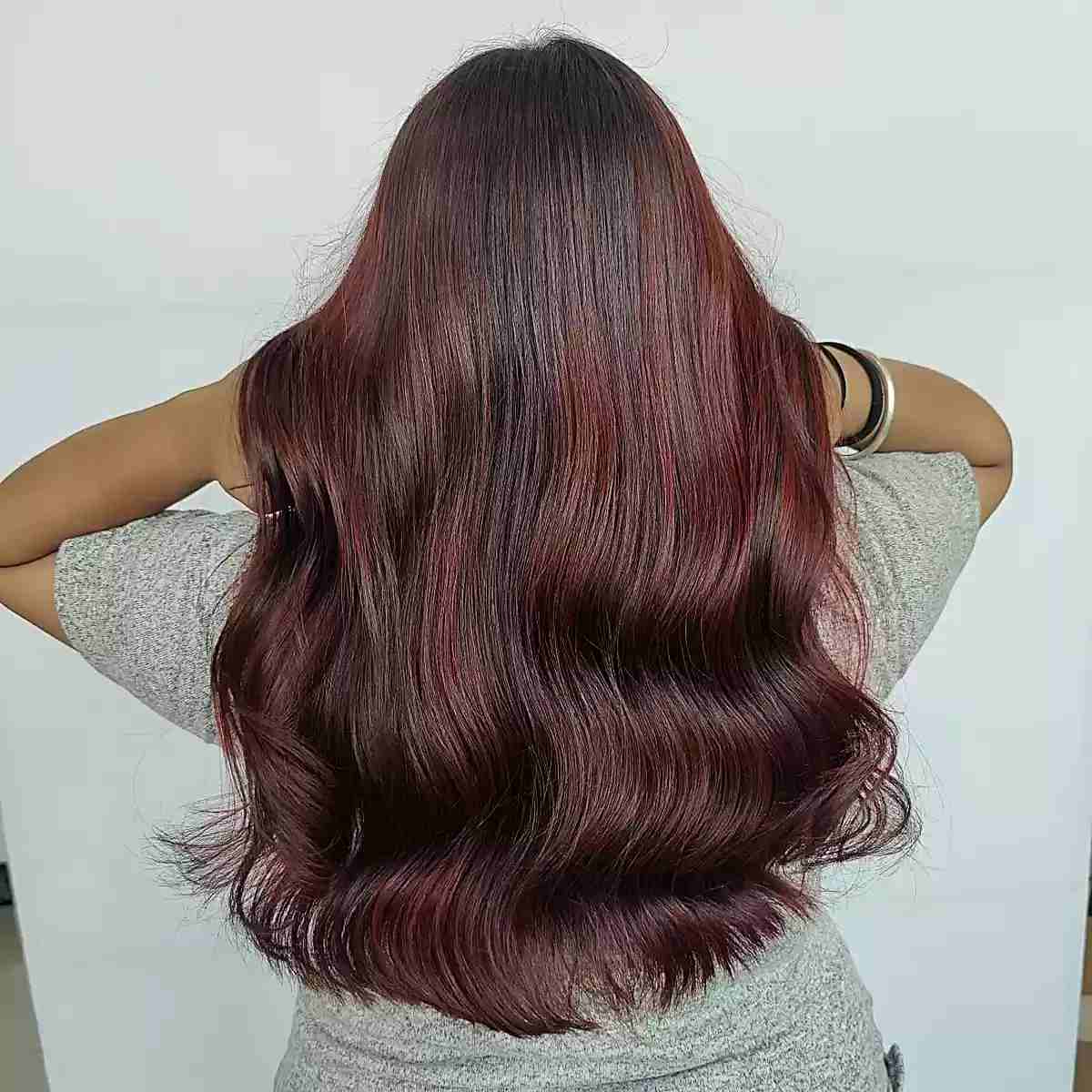 muted berry red balayage accents for long brownish locks
