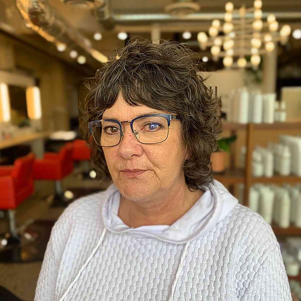 short curly shag with middle part bangs for senior women