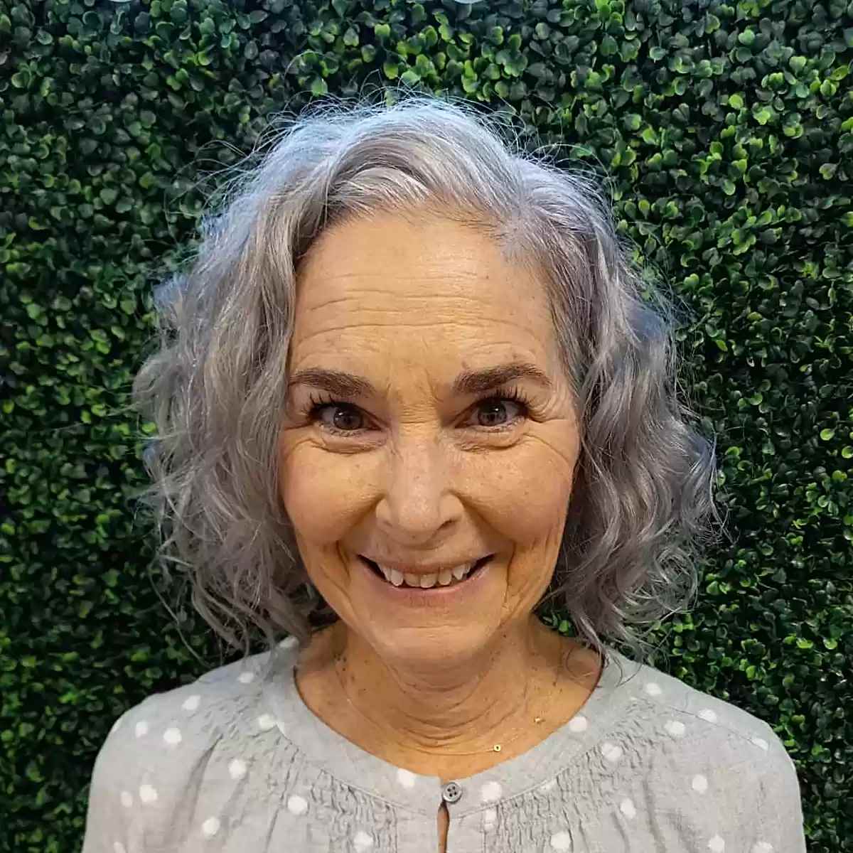 short layered grey curls with a deep side part on senior ladies