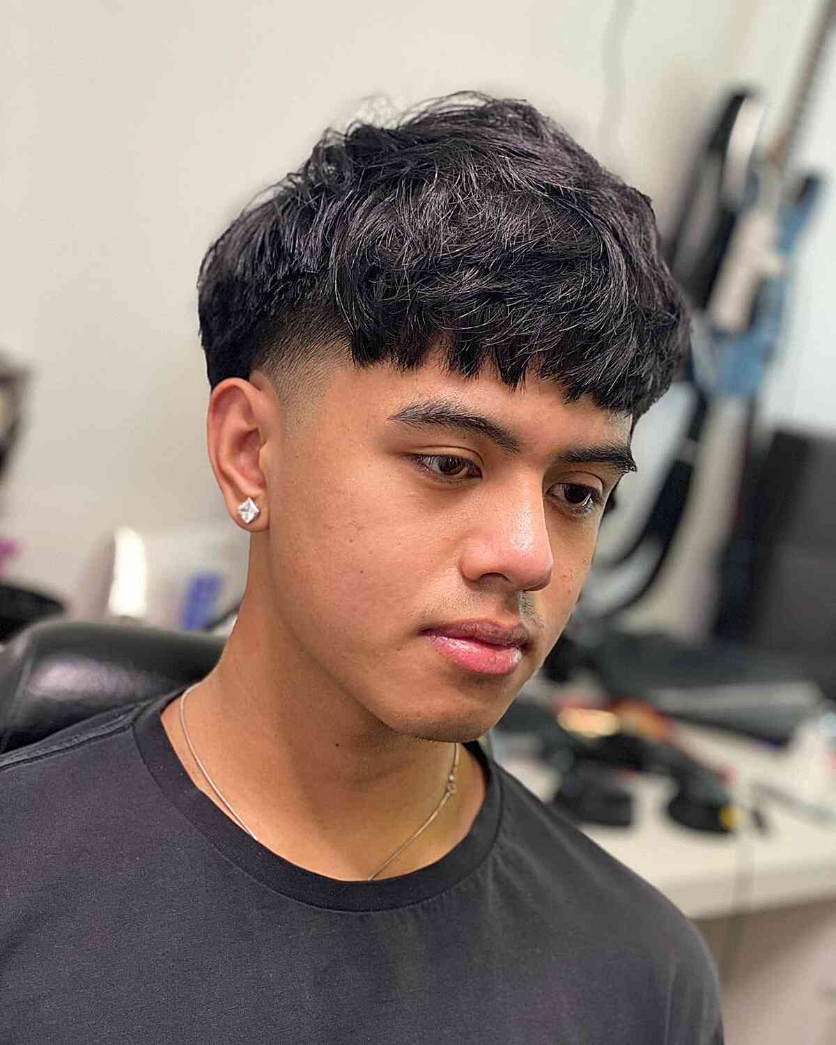 soft messy edgar cut with temple fade for a young man