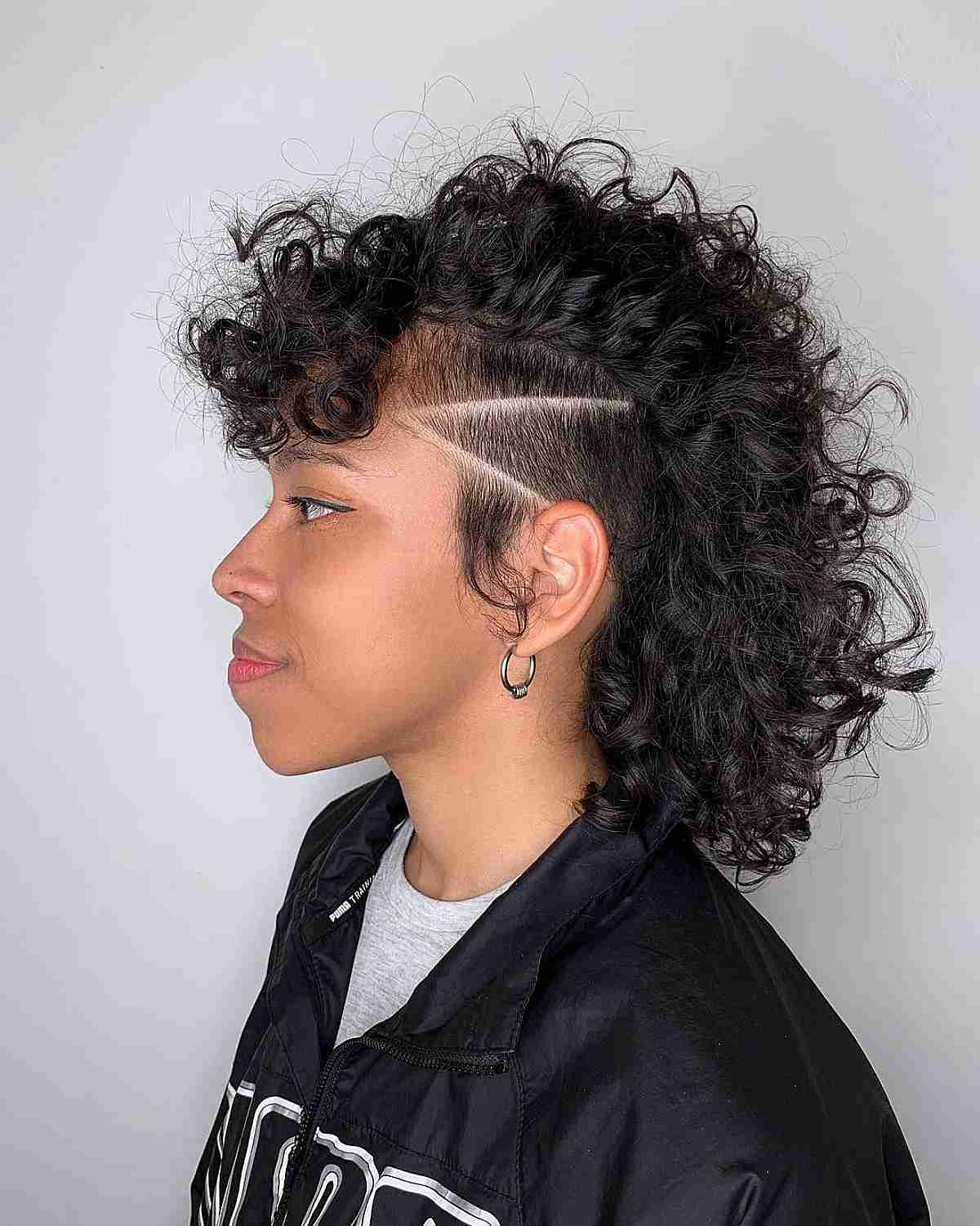 undercut mid length curly mohawk with buzzed lines